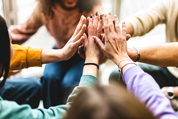 Young multiracial group stacking hands together