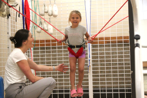 Therapist working with girl in bungee cords