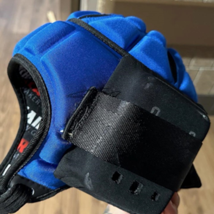 Blue and black padded head gear with black nylon straps and padded covers for the ears