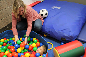 Therapist working with boy in ball pit