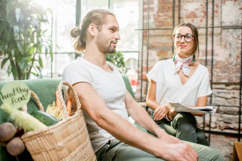 man with groceries and woman sitting next to him
