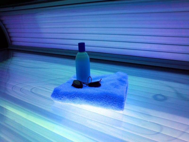 A folded towel and a bottle in a tanning bed.