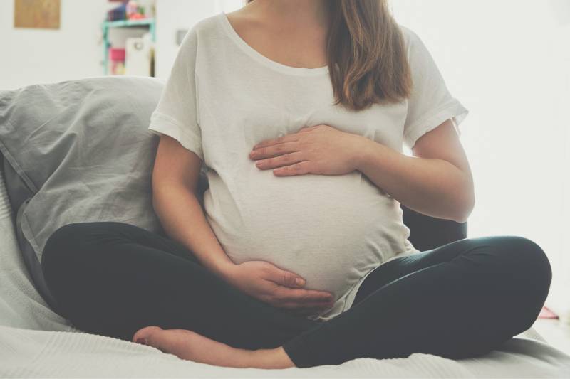 Pregnant woman holding belly