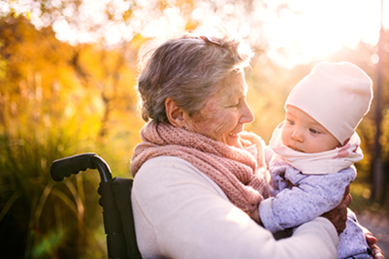 A grandma in a wheelchair holds her baby granddaughter.