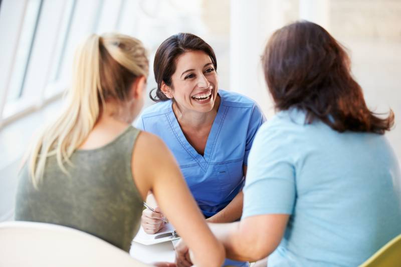 female physician talking with two women