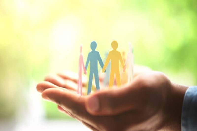 Hands hold group of cutout people.