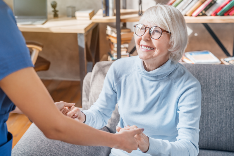 care worker assisting elderly woman in assisted living facility