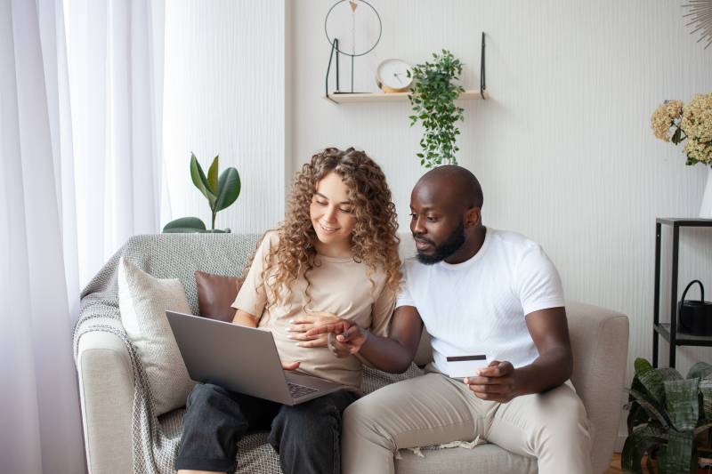 Expectant Mom with Partner Looking at Computer