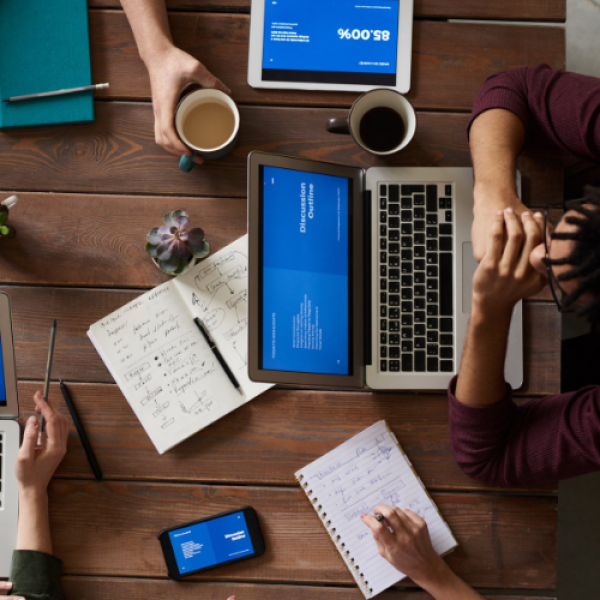 Overhead view of people on laptops around a table