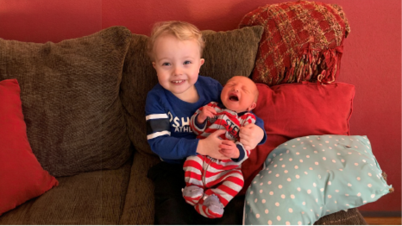 toddler holding baby brother