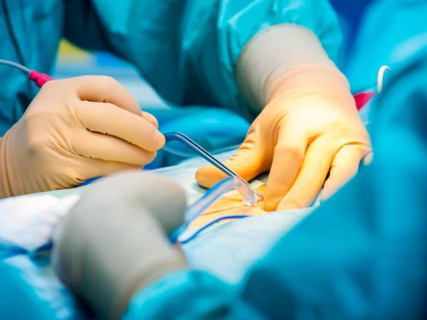 Hands performing surgery.
