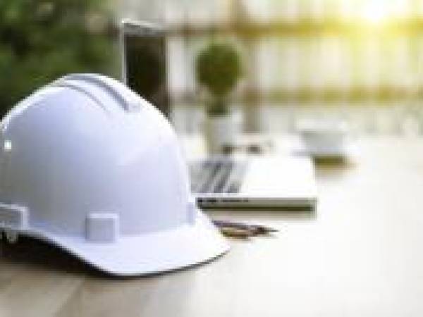 Safety hat on desk by laptop