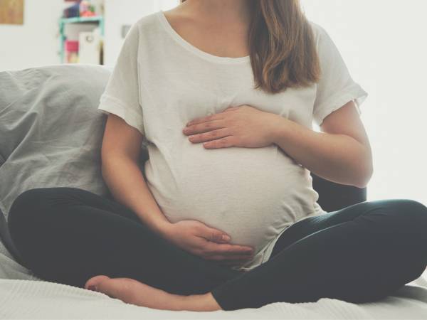 Pregnant woman holding belly