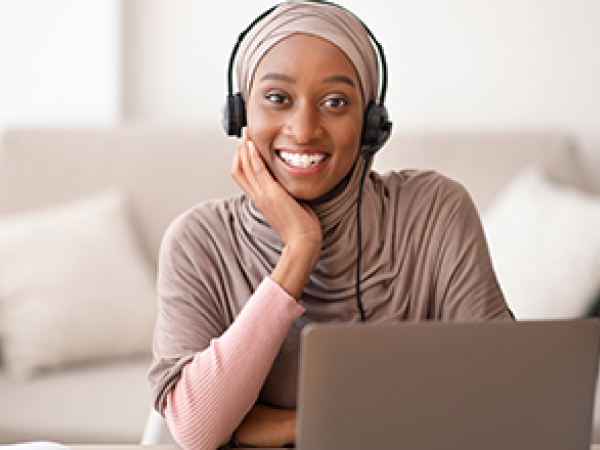 women wearing a headset working on a laptop computer
