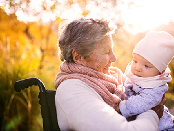 A grandma in a wheelchair holds her baby granddaughter.