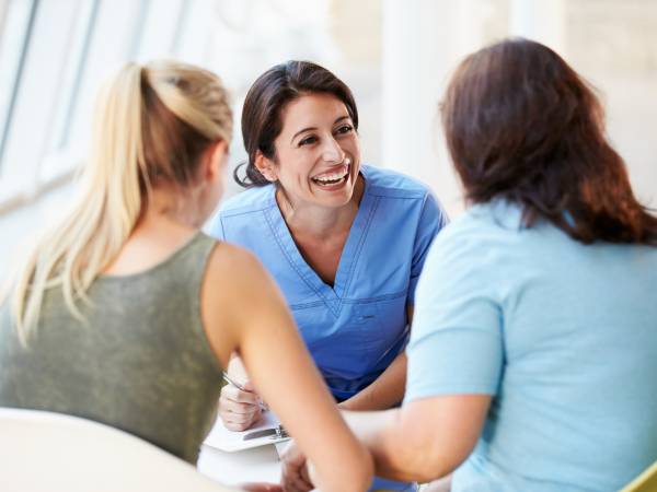 female physician talking with two women