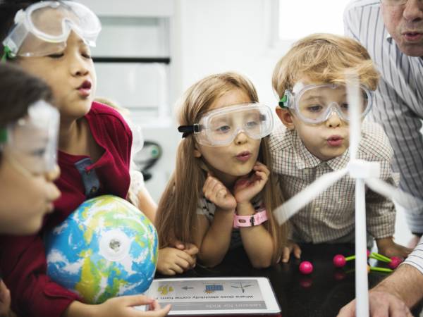 Young children doing a science experiment with teacher