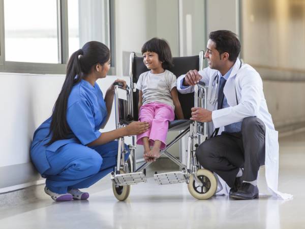 Child in wheelchair with medical providers