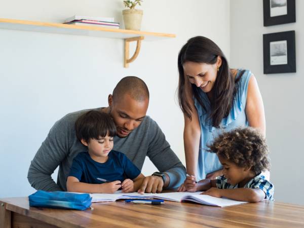 Kids doing homework at table with parents