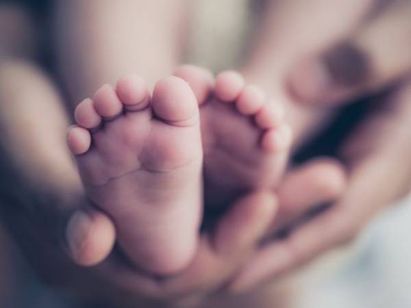 Holding newborn feet in hands