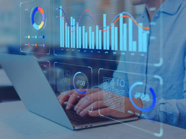 person typing on a laptop working with data charts dashboards