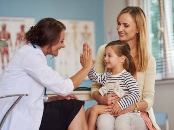 child giving a high five to female doctor