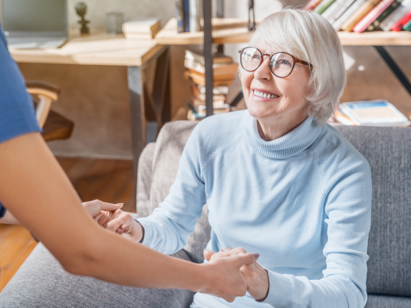 care worker assisting elderly woman in assisted living facility