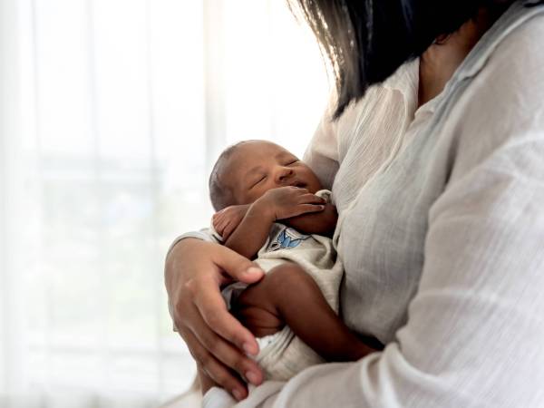 Close - Mother with infant nestled in her arms