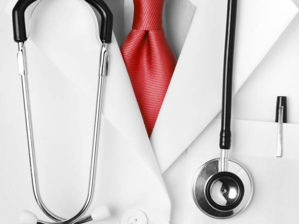 Close up of health care provider's white coat with stethoscope draped around neck