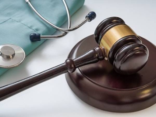 Gavel with scrubs and stethoscope