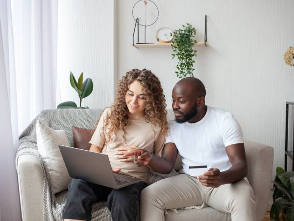 Expectant Mom with Partner Looking at Computer