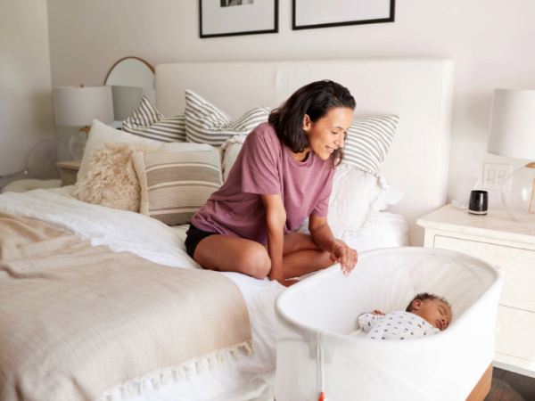 Woman looking at her baby in a crib