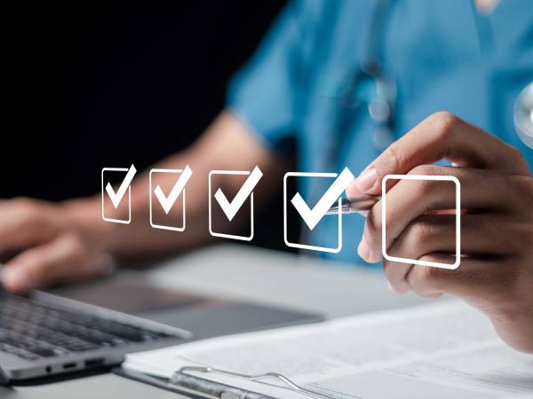 Image of Health Care Professional on Computer with Checkmarks