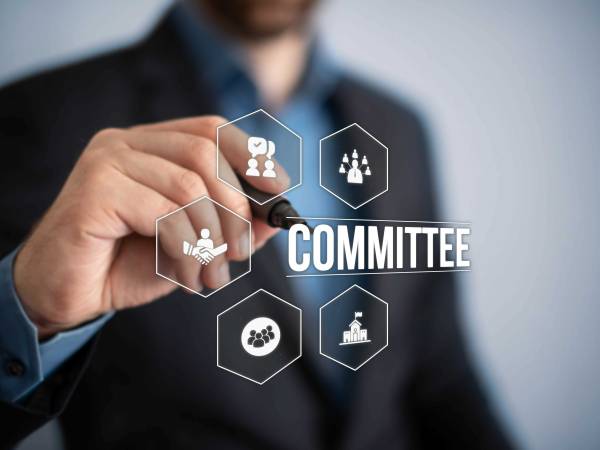 Individual writing "committee" on board 