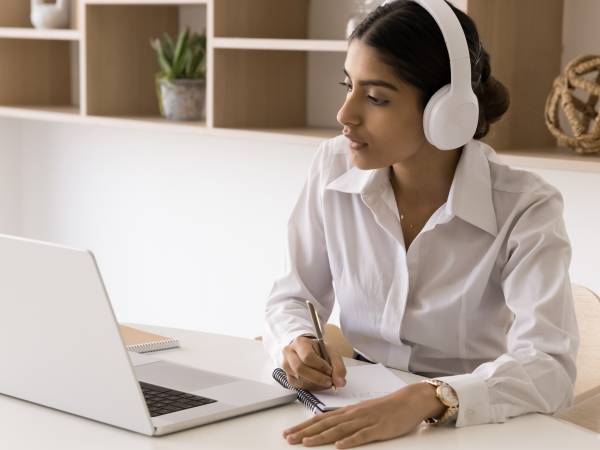 Woman working at a computer with headphones on