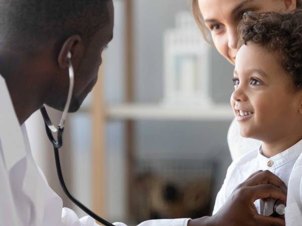 A doctor listening to a child's heart with a stethoscope