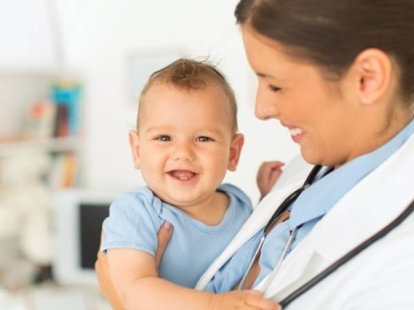 woman physician holding infant