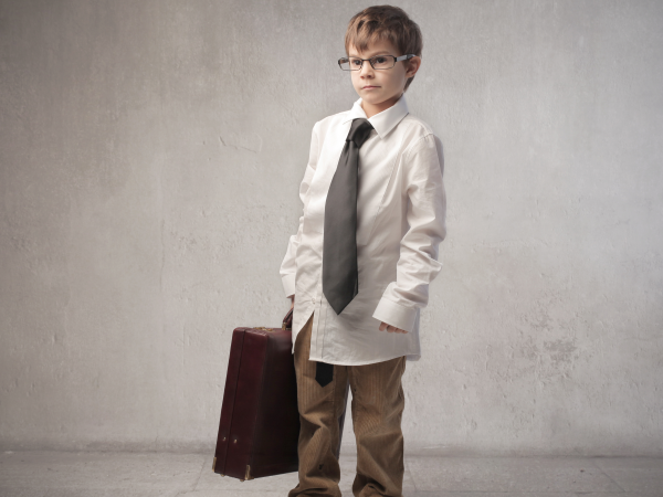 young boy in a suit holding a briefcase
