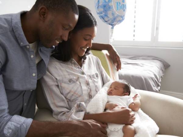 New parents cuddle their newborn