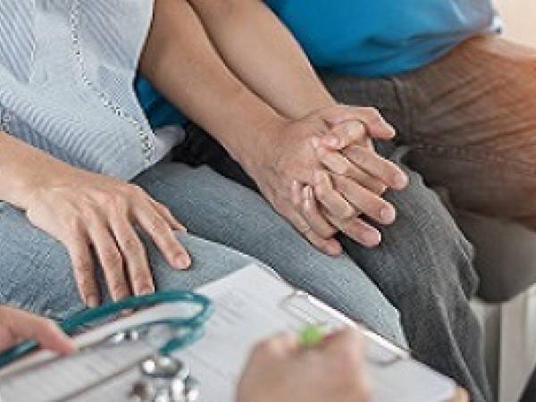 Couple holding hands and receiving counseling