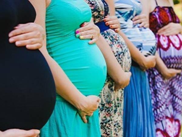 Several pregnant women with hands on belly
