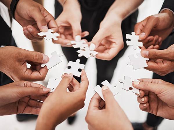Hands holding puzzle pieces.