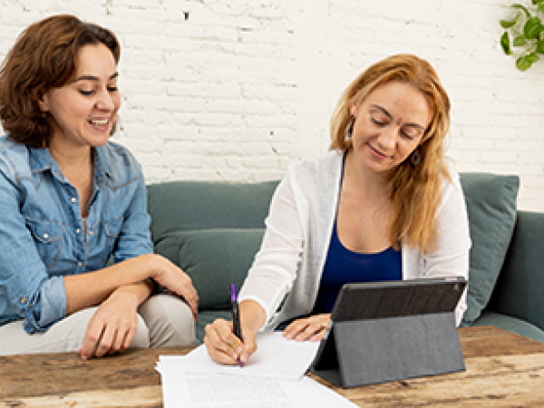 Two women filling out paperwork.