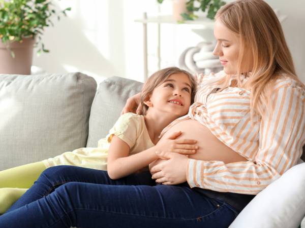 Pregnant women with a child on the couch