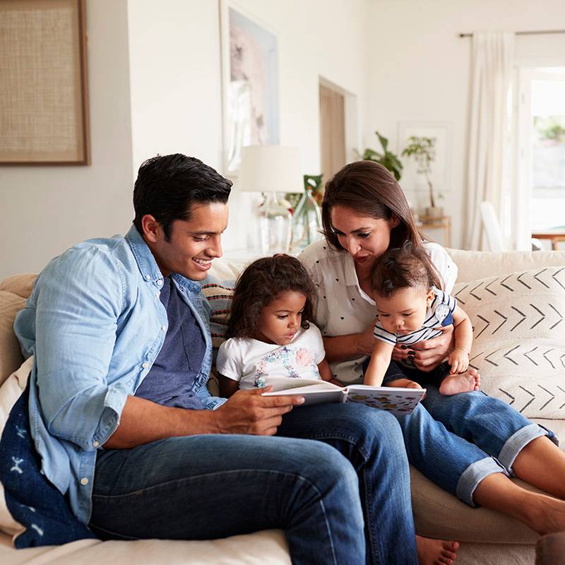 Parents Reading Book to Children