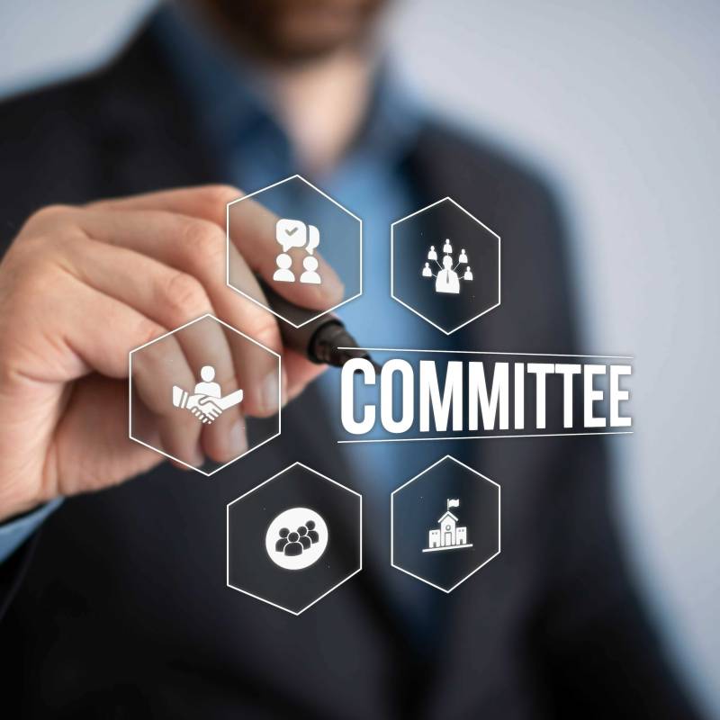Individual writing "committee" on board 