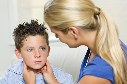 Mother checking for swollen lymph glands on her son