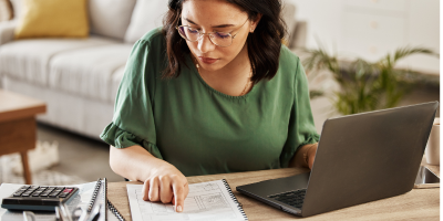 woman at table with computer and papers