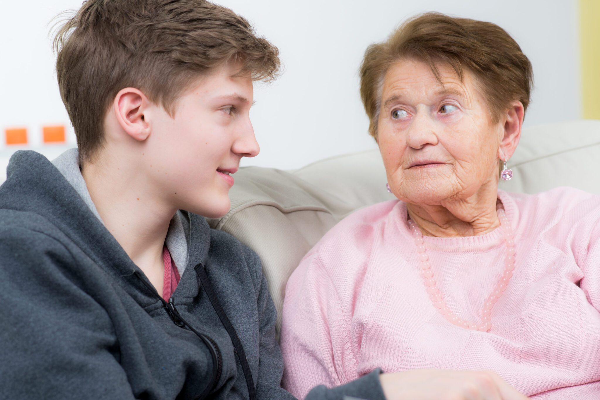 A teenage boy having a conversation with his grandmother.