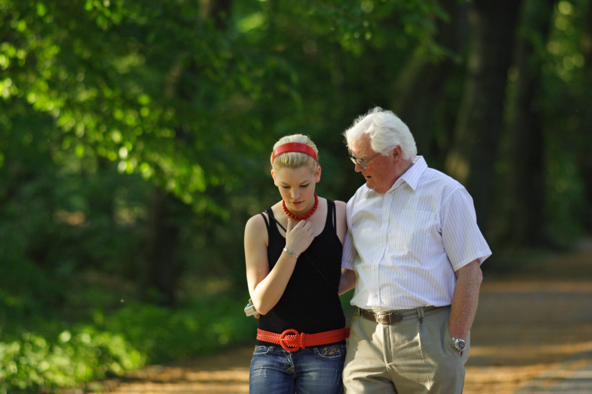 A grandfather walking with an older grand daughter.